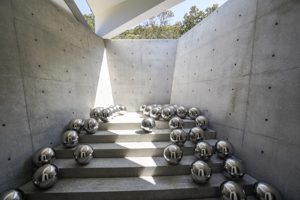 A photo of a concrete chamber filled with reflective stainless steel balls.